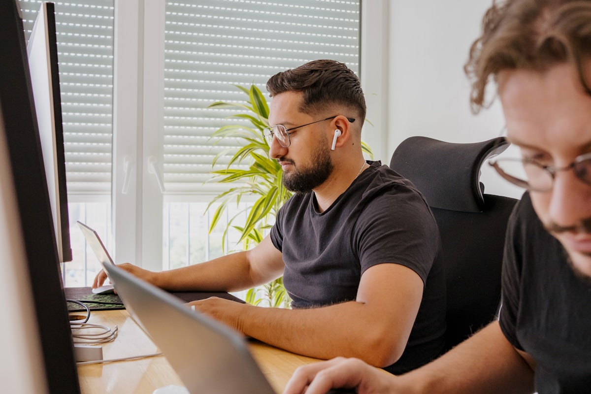 An analyst reviewing code on multiple screens